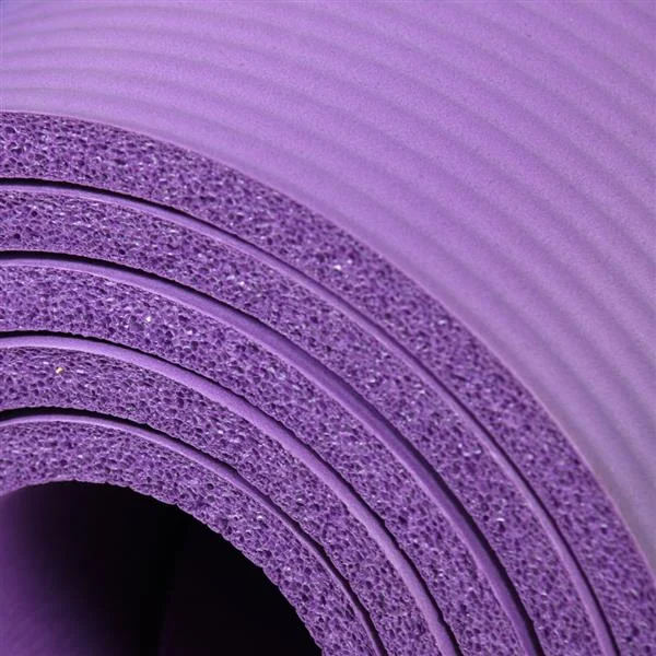 Close-up of a rolled purple NBR foam yoga mat showing its ribbed surface and thick layered texture