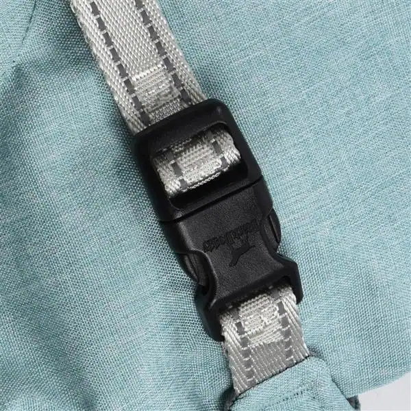 Close-up of a black side-release buckle and gray strap sewn onto light blue waterproof dog jacket fabric