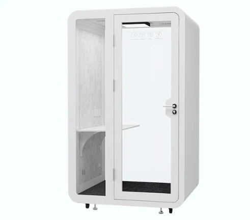 White single-person noise reduction office pod with glass door and interior shelf, isolated on a plain background.