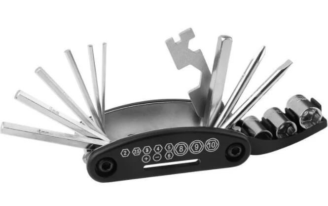 Folding bicycle multi-tool with hex keys, wrenches and sockets fanned out from a black body on white background