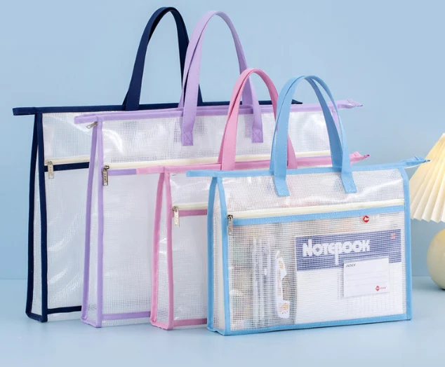 Four clear PVC zipper tote bags in navy, purple, pink and blue, one filled with a notebook and stationery
