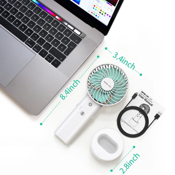 Top-down view of a white handheld fan with teal blades, USB cable, and stand next to a laptop.