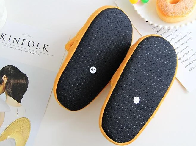 Top view of the soles of yellow simulated bread slippers showing black non-slip bottoms and size 41 labels