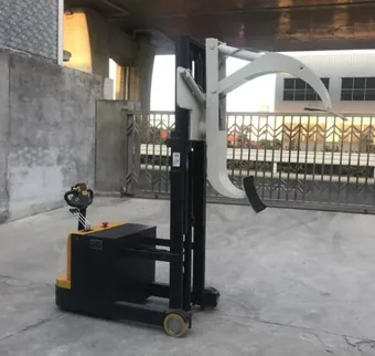 Automatic rotable roll lifter with white arms and black base parked on concrete surface