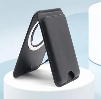 Black leather magnetic phone card holder folded into a stand on a white pedestal against a light blue