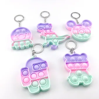 Five pastel gradient silicone pop-it keychains shaped like a dinosaur, bear, and other designs