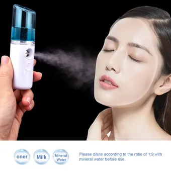 Hand holding a portable blue and white nano facial mister spraying mist onto a woman's face.