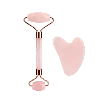 Rose quartz face roller with rose gold frame beside a heart-shaped gua sha stone on a white background