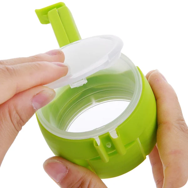 Two hands holding a green plastic bag sealing clamp with flip-top pour spout, white background