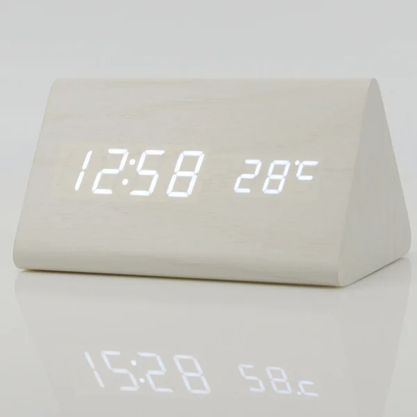 Clock next to a mug and book on a bedside table, demonstrating its use in a bedroom environment