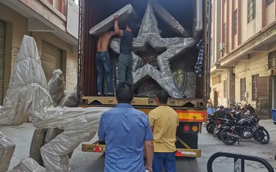 A large star motif being loaded, wrapped and braced for container transport.