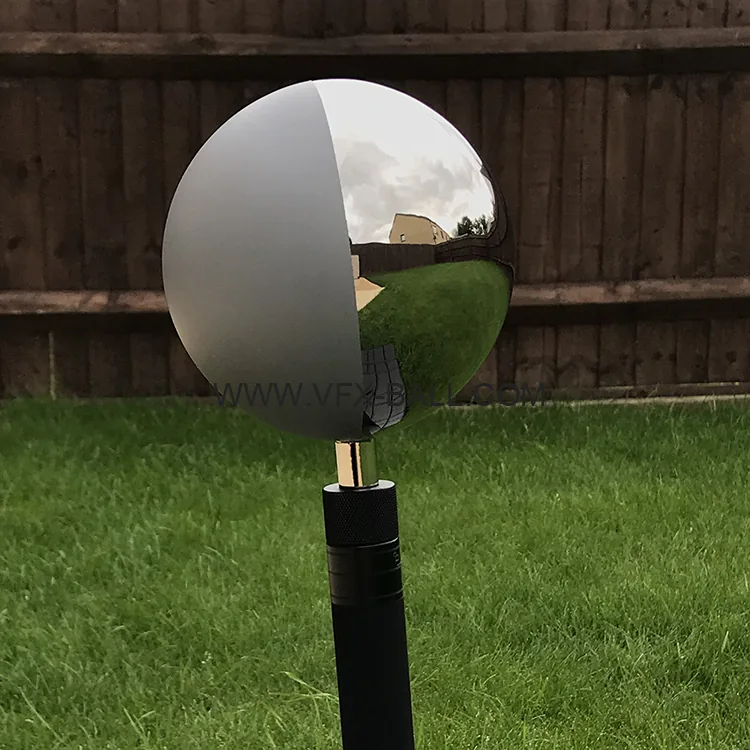 12.6cm half mirror half grey ball on a stand in front of a fence