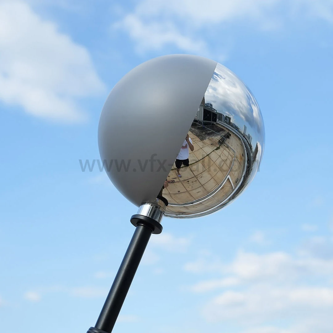 20cm half mirror half grey VFX ball held against a clear sky