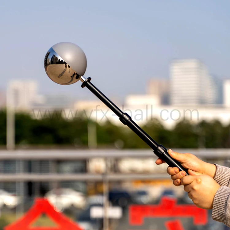 5 inch 50 50 chrome and grey VFX ball held on a handle in a city street