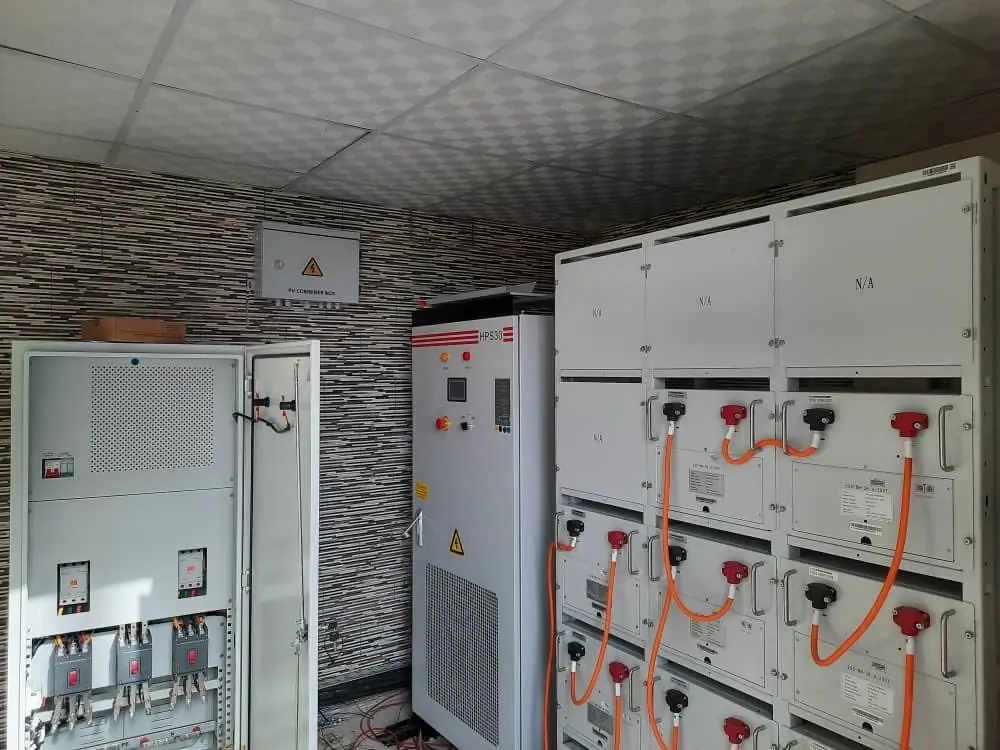 Interior of an industrial electrical room featuring large grey switchgear cabinets and orange cables.
