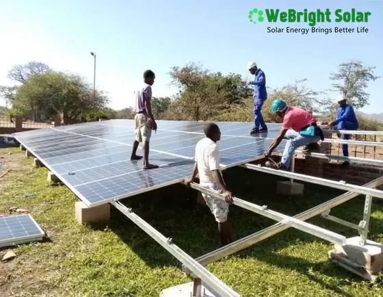 Five men installing solar panels onto a metal mounting frame outdoors.