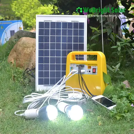 Portable solar generator kit with panel and light bulbs set up on grass outdoors.