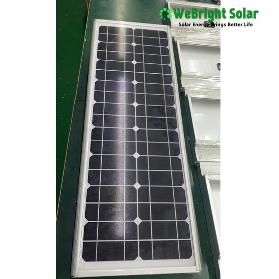 A long, narrow solar panel lying on a green floor.