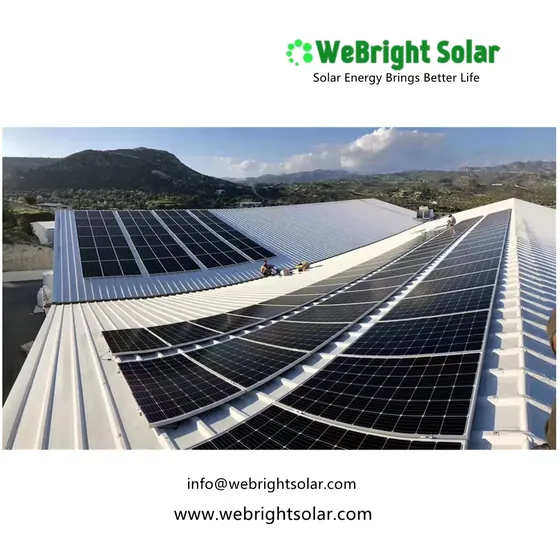 Rooftop solar panel installation on a large white building with workers visible on the roof.