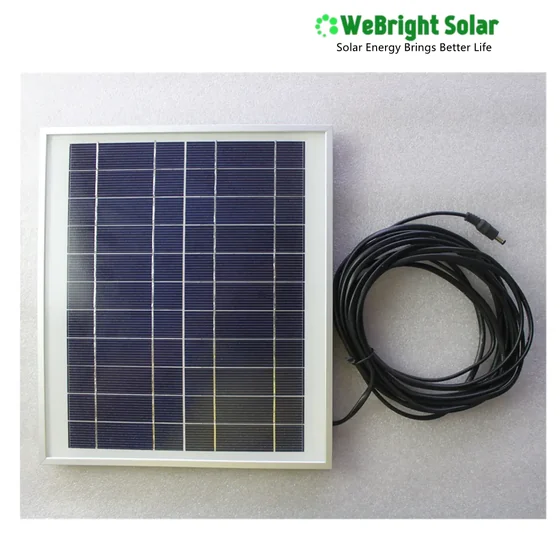A small framed solar panel with a coiled black cable and connector, set against a plain grey background.