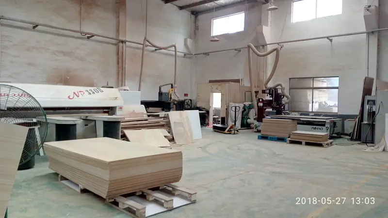 Panel saw and stacked board stock in the cutting area of the WEFOR workshop. Cabinet sides tops and leg panels