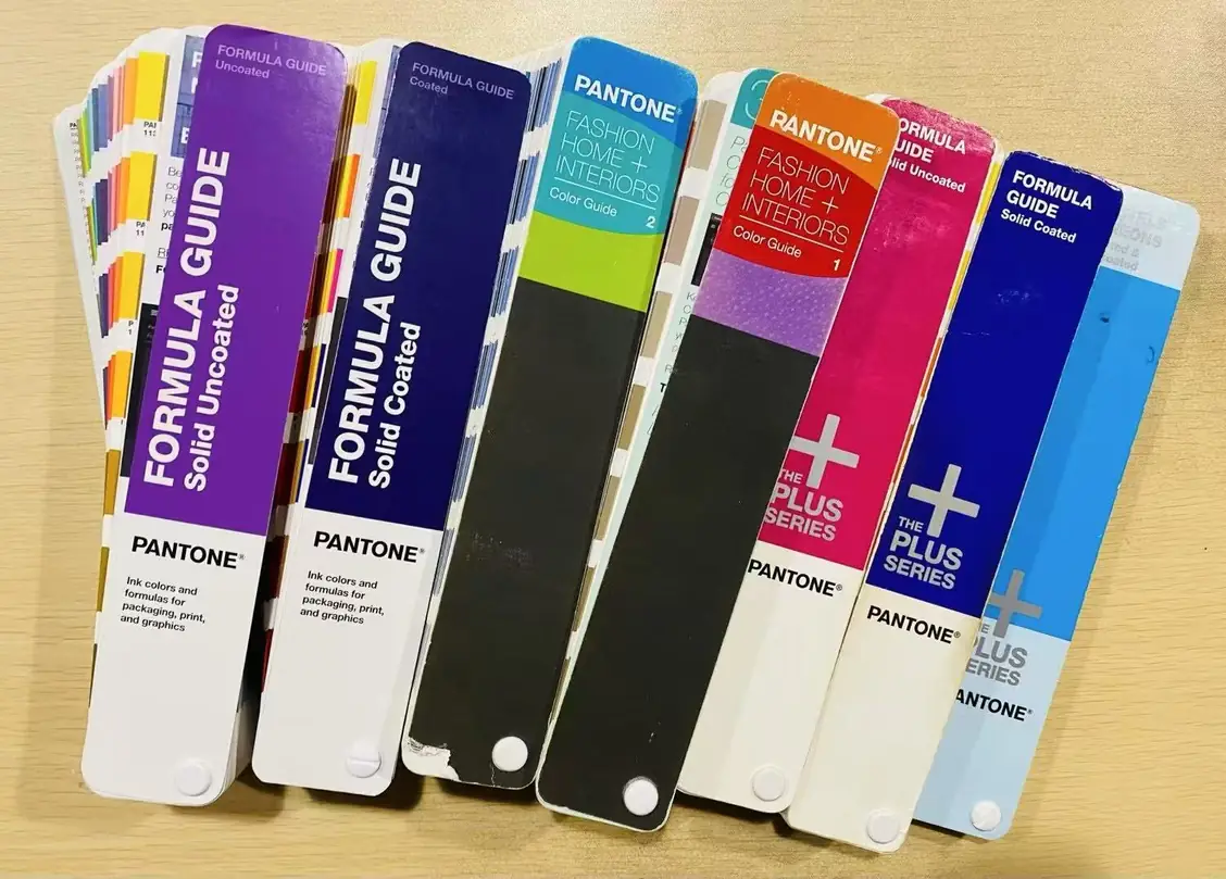 Pantone formula guides fanned out on the colour matching bench