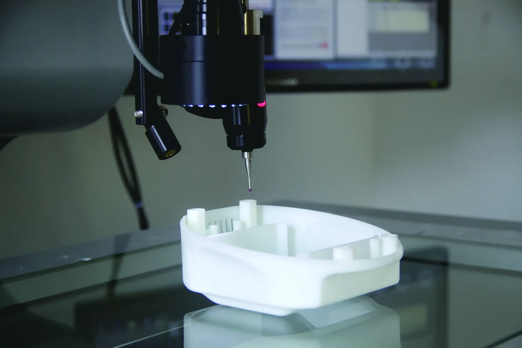 Coordinate measuring machine probe inspecting a moulded white component