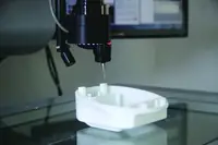 Coordinate measuring machine probe inspecting a moulded white component