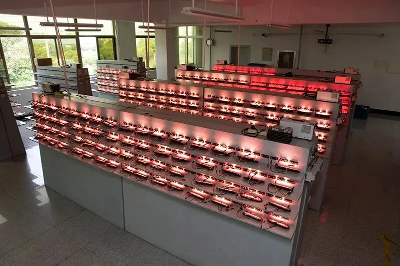 Aging test racks with hundreds of red LED truck lamps powered on