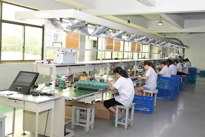 Assembly line workers fitting LED lamp components