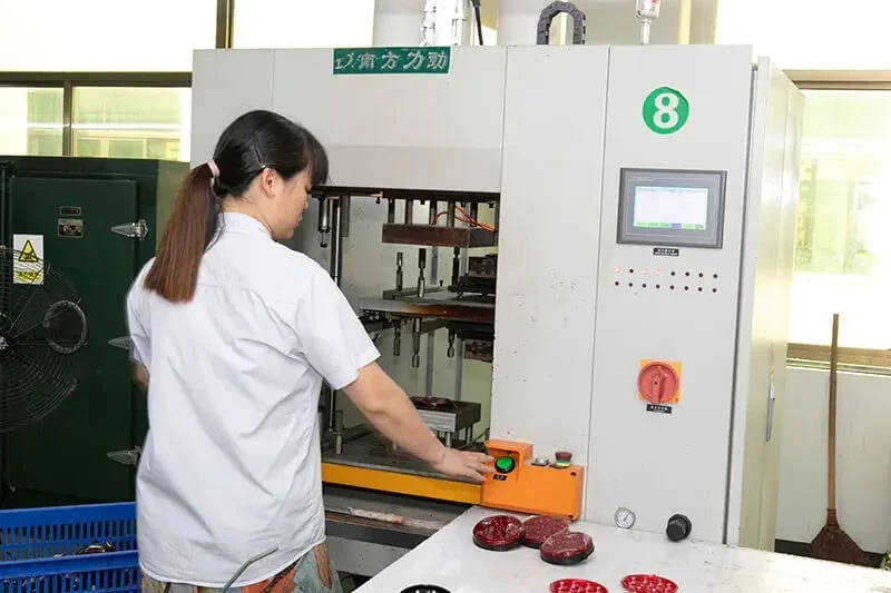 Operator running an ultrasonic welding press on red lamp lenses