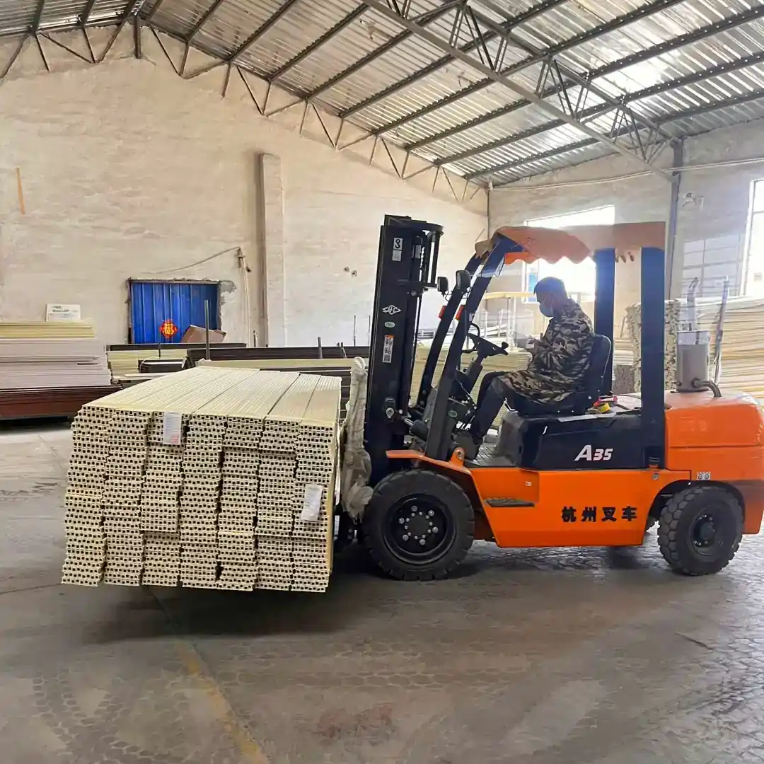 Forklift moving a bundled pallet of fluted wall panels inside the factory