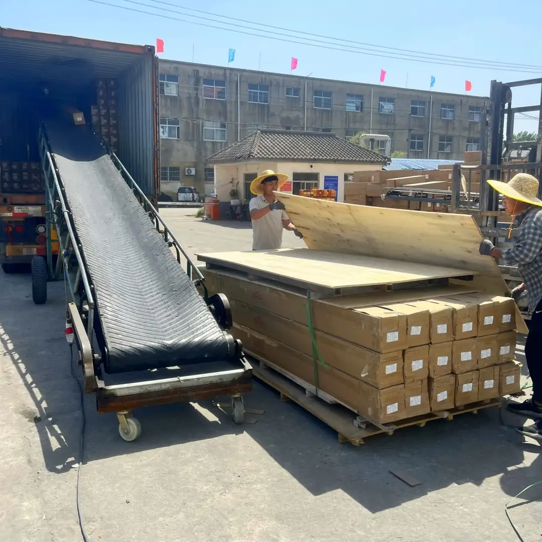 Factory staff loading packed panel bundles into a shipping container