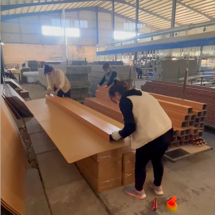 Factory staff handling and packing WPC wall panel boards in the workshop