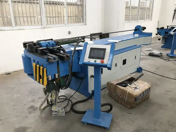 CNC pipe bending machine showing the feed carriage bend arm and touch-screen operator panel