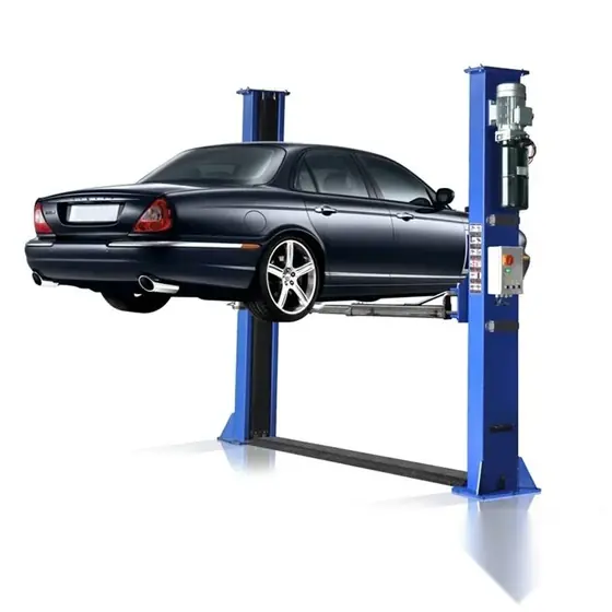 Two post auto car lift with two upright columns swing arms and lifting pads standing on a workshop floor