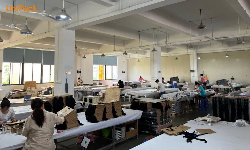 Paper bag workshop at the Xiamen UniPack factory with workers assembling printed paper bags
