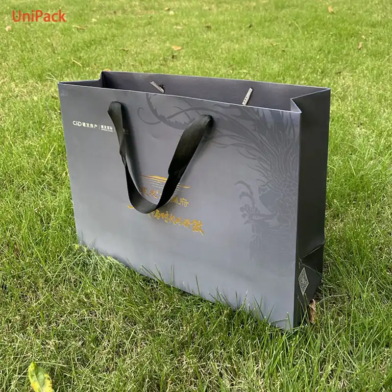 White art card luxury shopping bag with gold foil stamped brand logo