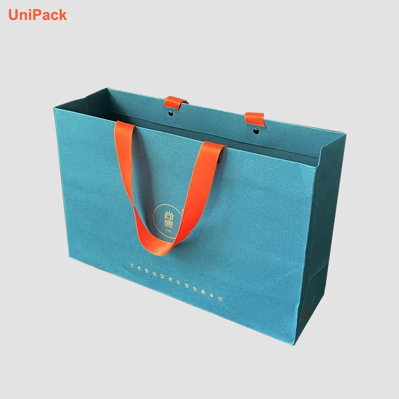 Coloured paper bag with metal eyelet handles and gold foil stamped logo