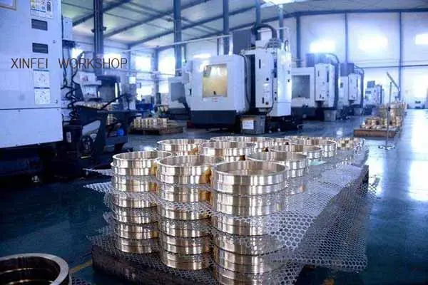 Ground bearing rings and machined brass cages staged beside the turning line