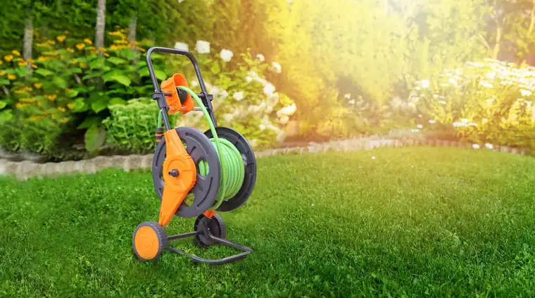 Two wheel garden hose cart standing on a lawn