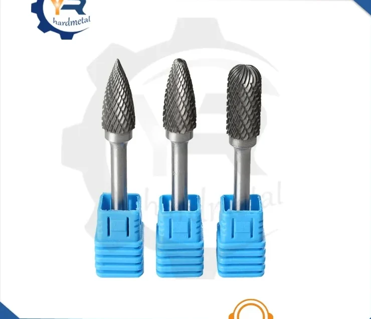 Three tungsten carbide rotary burrs with cylindrical shanks, each seated in a blue plastic handle