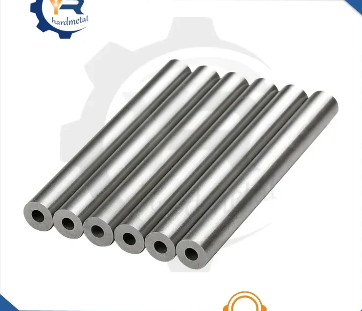 Tungsten carbide rods with central coolant holes lined up on a white background