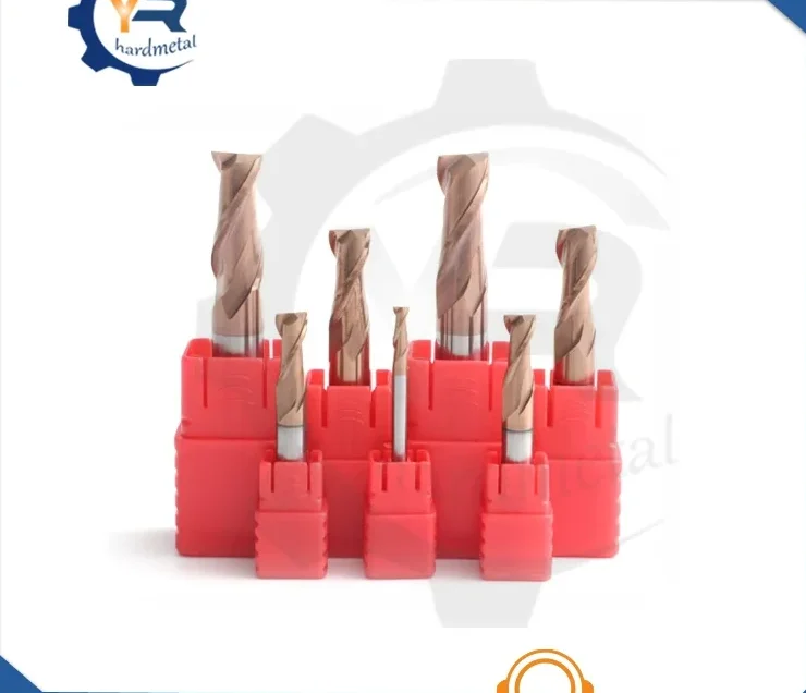 Solid carbide end mills with copper-colored spiral flutes standing upright in red plastic holders