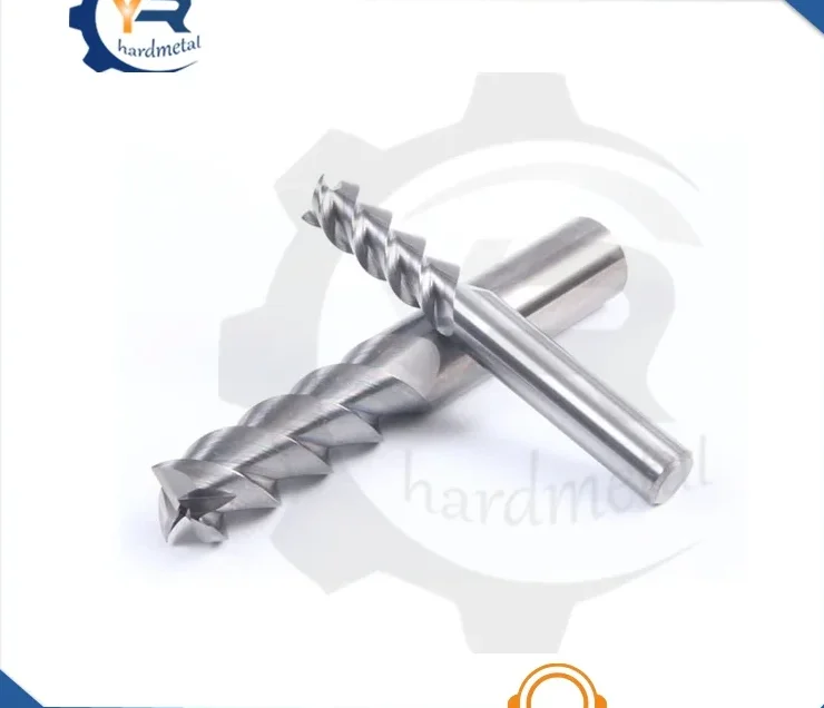 Two carbide end mills with helical flutes crossed on a white background