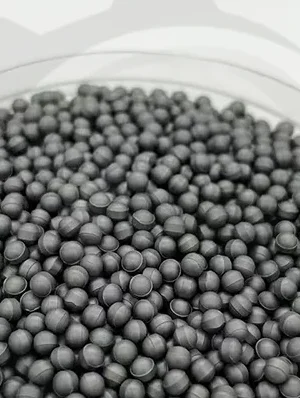 Bulk pile of small dark gray tungsten carbide balls filling a round container