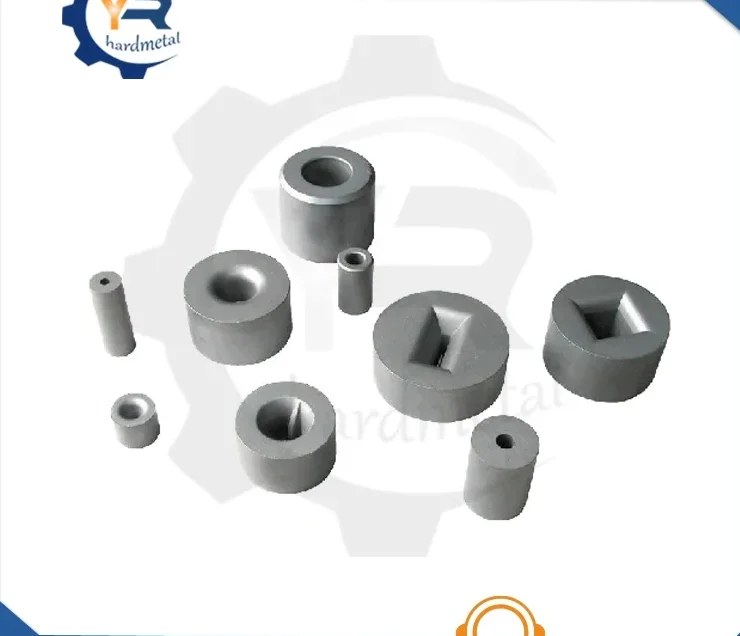 Assorted gray tungsten carbide dies with round and square bores arranged on a white background