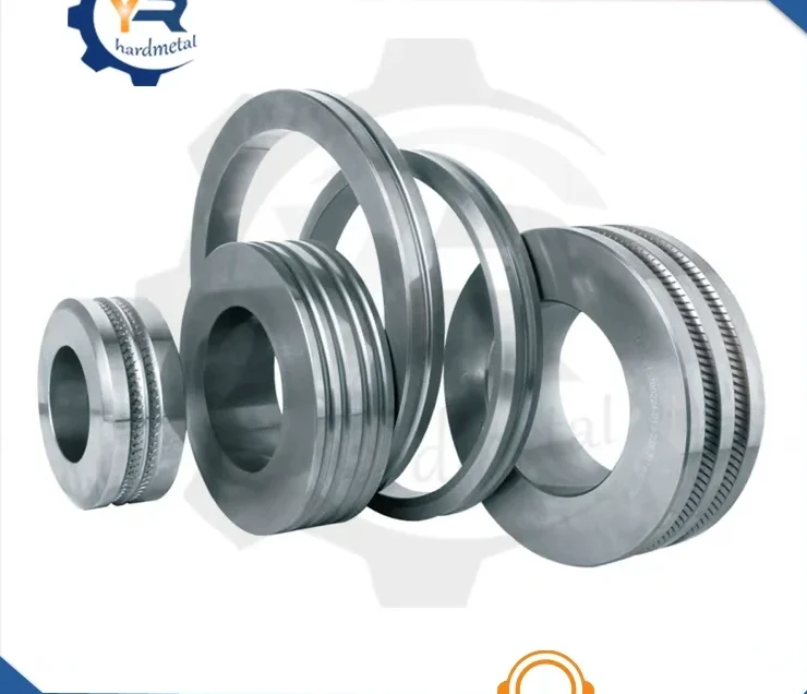 Polished tungsten carbide roll rings with grooved profiles standing upright on a white background