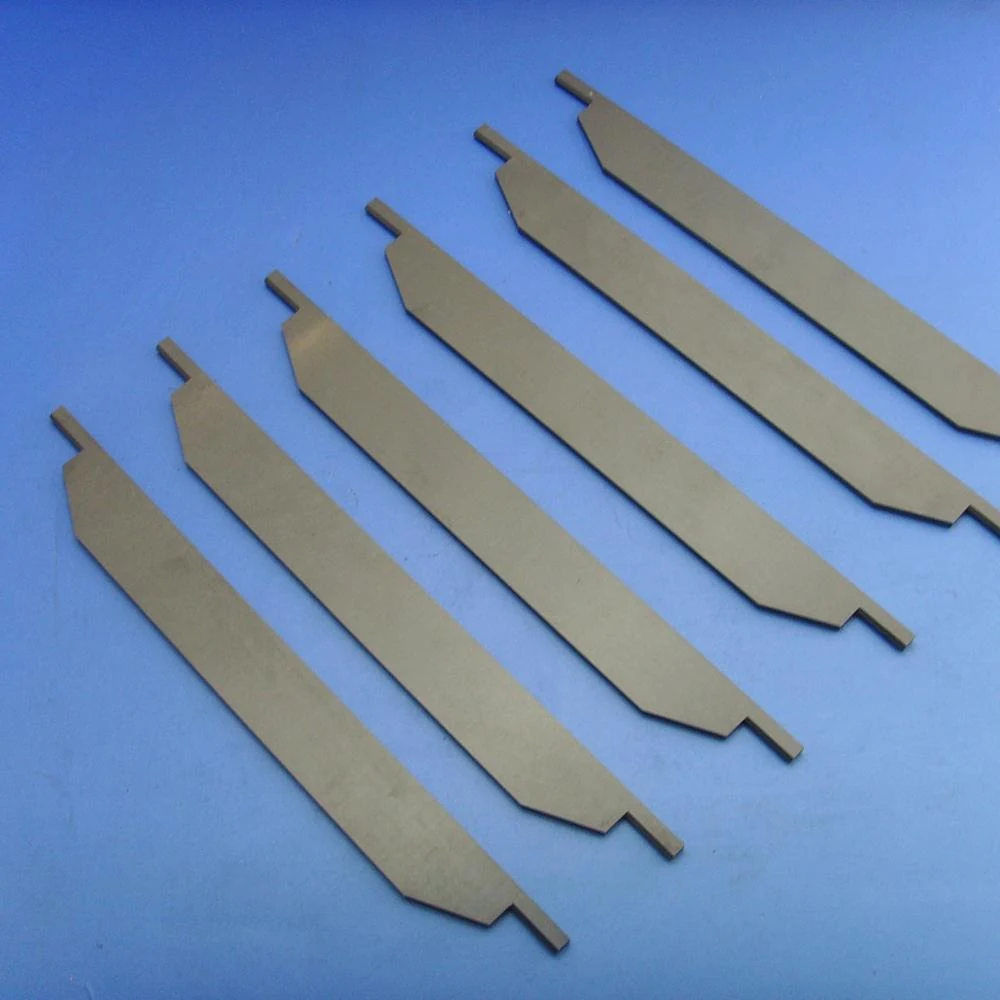 Row of white ceramic blades with ground cutting edges on a blue background