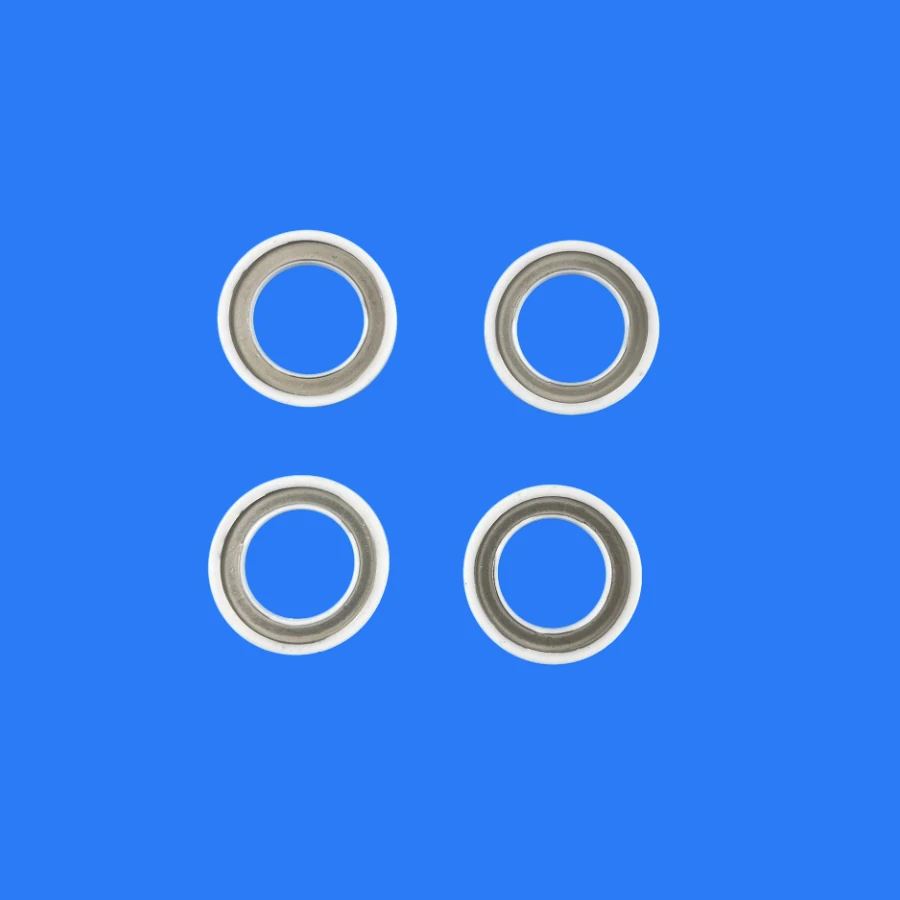 Four metallized alumina ceramic rings with bright metal bands on a blue background